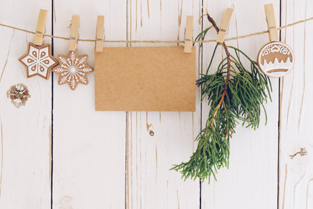 christmas decoration and blank paper card hanging on wood background.の写真素材
