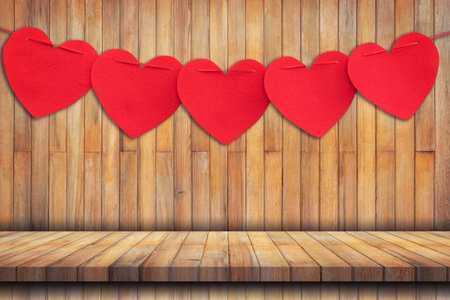 Red heart hanging on Wood table Background and Texture vertical.の写真素材