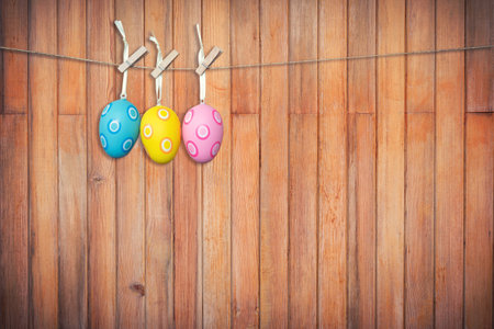 Colorful easter eggs hanging on wooden background, Vintage toned.の写真素材