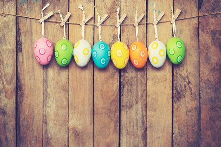 Colorful easter eggs hanging on wooden background, Vintage toned.の写真素材