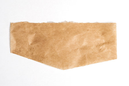 Close up of a ripped piece of brown paper on white background