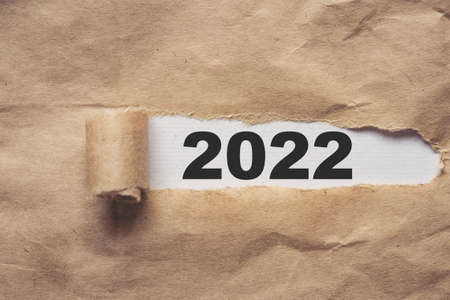 Brown package paper torn to reveal white panel New year 2022の写真素材