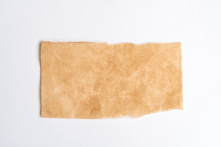 Close up of a ripped piece of brown paper on white backgroundの写真素材