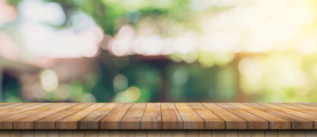 Empty wood table and defocused bokeh and blur background of garden trees with sunlight. product display template.の写真素材