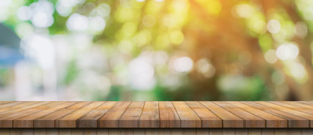 Empty wood table and defocused bokeh and blur background of garden trees with sunlight. product display template.の写真素材