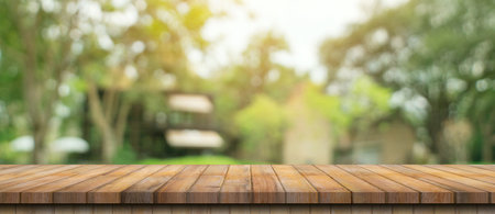 Empty wood table and defocused bokeh and blur background of garden trees with sunlight. product display template.の写真素材