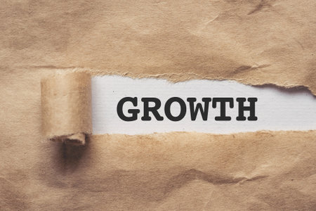 Torn brown paper on white background the text growthの写真素材