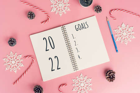 Notebooks with empty goals for 2022 year and christmas decorations on color backgroundの写真素材
