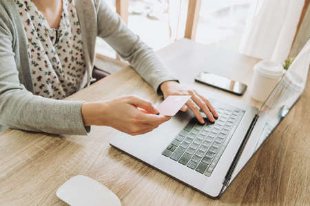 woman using smart phone and credit card for shopping online in coffee shopの写真素材
