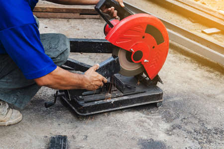 Worker man cutting steel with a circular steel cutter.の写真素材