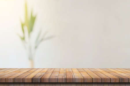 Wooden table top with blurred people in coffee shop and cafe background for display montage, copy space.の写真素材