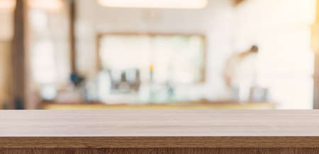 Wooden table top with blurred people in coffee shop and cafe background for display montage, copy space.の写真素材