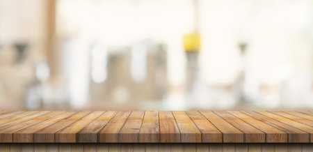 Wooden table top with blurred people in coffee shop and cafe background for display montage, copy...