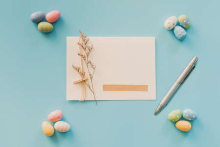 Easter eggs on blue background and greeting card with copy space for textの写真素材