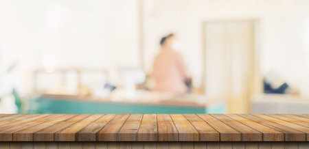 Wooden table top with blurred people in coffee shop and cafe background for display montage, copy space.の写真素材