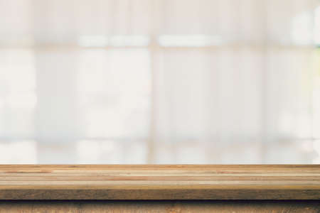 Wooden table top with blurred people in coffee shop and cafe background for display montage, copy space.の写真素材