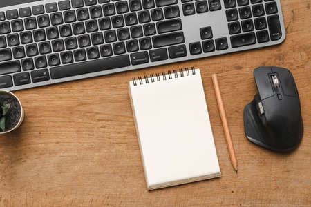 Wood desk table with blank notebook with pencil, keybourd computer and suppliesの写真素材