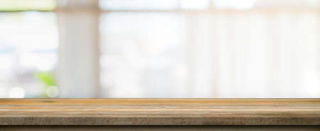 Wooden table top with blurred people in coffee shop and cafe background for display montage, copy space.の写真素材
