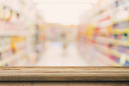 Wood table top on blurred background from shopping mall, Space for montage your product.の写真素材