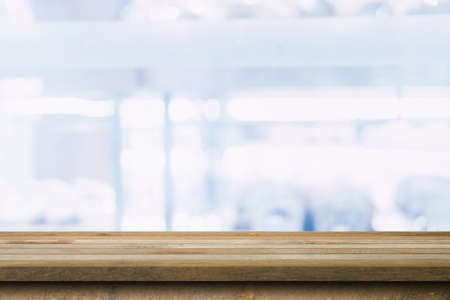Wood table top on blurred background from shopping mall, Space for montage your product.の写真素材