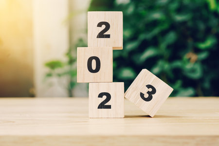 2023 happy new year on wood block on wood table with sunlight. new year concept.の写真素材