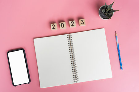 Notebooks with empty goals for 2023 year and phone on color backgroundの写真素材