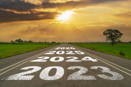 Empty asphalt road and New year 2023 concept. Driving on an empty road to 2023 with sunset.の写真素材