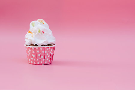 Tasty cup cake on pink background with copy spaceの写真素材