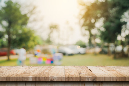 Empty wooden table top and Abstract blurred light bokeh and blur background of garden trees in sunlight. product display template with copy space.の写真素材