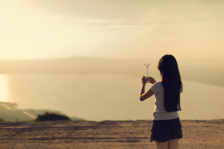 Woman holding a small wind turbine The atmosphere, that had the heat on Mount White balance is yellow and simulateの写真素材