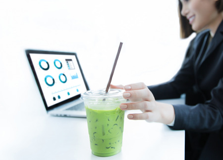 Business women are picked green tea drink during workの写真素材