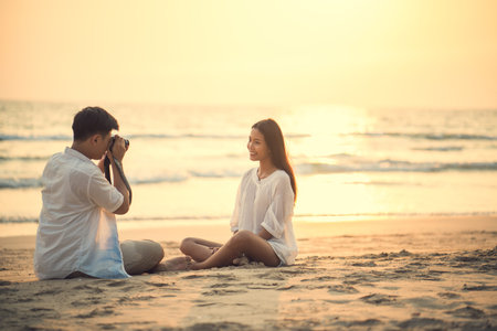 Couples taking pictures each other He was at the beach in the evening.の写真素材