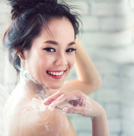 Asian women are taking a shower in the bathroom she is rubbing soap,she is happy and relaxed.の写真素材