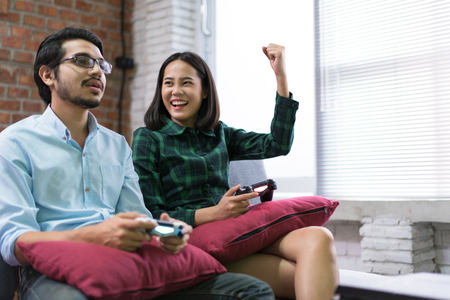 Lovers are playing at home. They know fun, excited. Woman he is winners.の写真素材