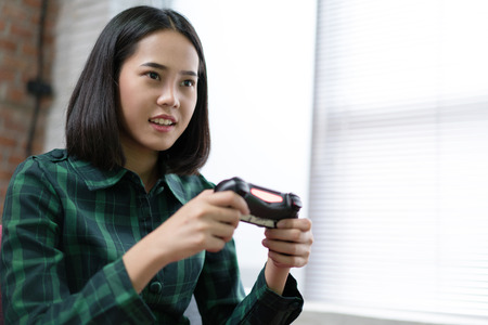 Woman playing game at home.の写真素材