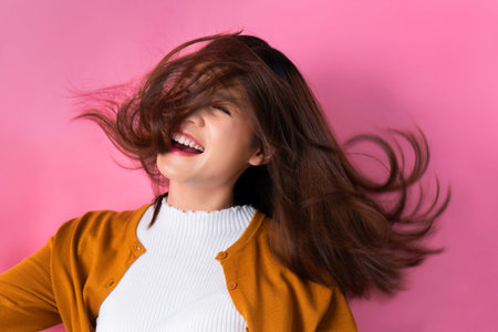 Asian woman smiling happily on pink background