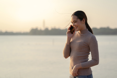 Asian woman talking on the phoneの写真素材