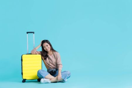 Asian women tourists with a yellow suitcaseの写真素材