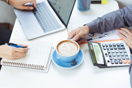 Asian businessmen are discussing proposals for finding ideas in coffee shops.の写真素材