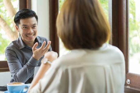 Asian businessmen are discussing proposals for finding ideas in coffee shops.の写真素材