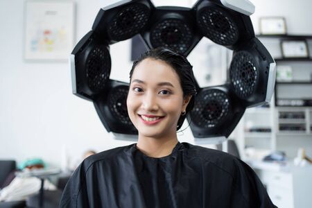 Asian woman dyeing hair in a beauty salonの写真素材