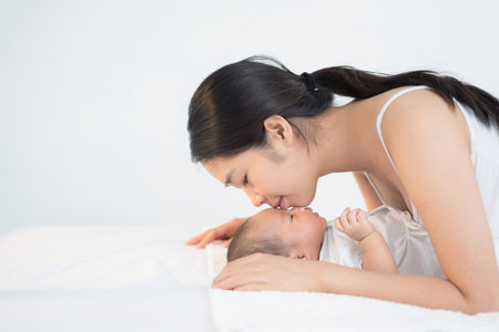 Mother kisses the baby's foreheadの写真素材