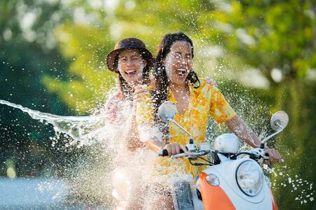 Asian people play songkran festival in the summer april They ride motorcycles. Then hit the waterの写真素材