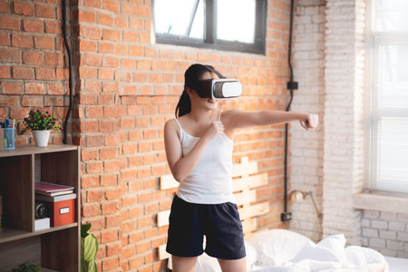 Asian women exercise indoor at home  She is using VR glasses in boxing.