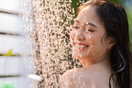 Asian woman, she uses a shower and wash hair outside. She is resting at the resort.の写真素材