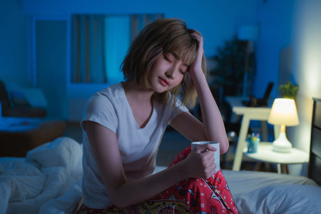 Asian women drink tea in bed before bed.