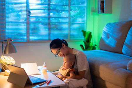 Asian mother and child Sitting and working at home at nightの写真素材