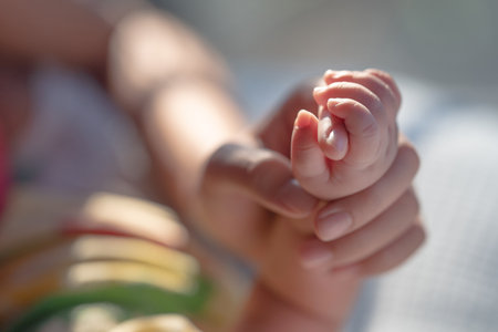 Newborn baby is holding the mother's handの写真素材