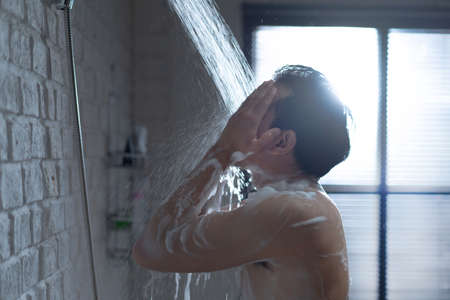 Handsome asian guy Taking a shower in the bathroomの写真素材