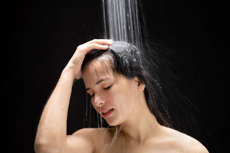 Asian woman She takes a shower and washes her hair. in the black backgroundの写真素材